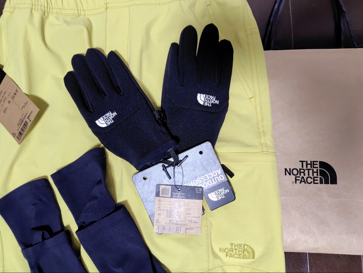 購入した黄色のハーフパンツと手袋、THE NORTH FACEの紙袋