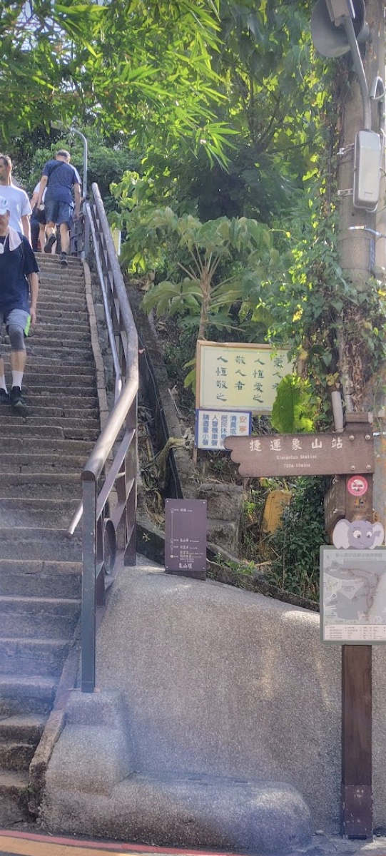 手すりのついた、象山の整備された石の階段。前を地元の人が登っている