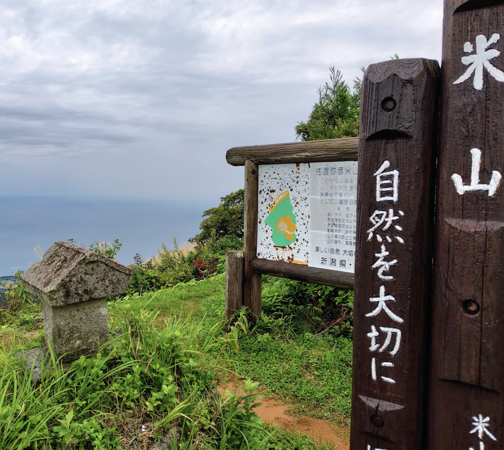 米山山頂の案内板（佐渡弥彦米山国定公園）と石祠
